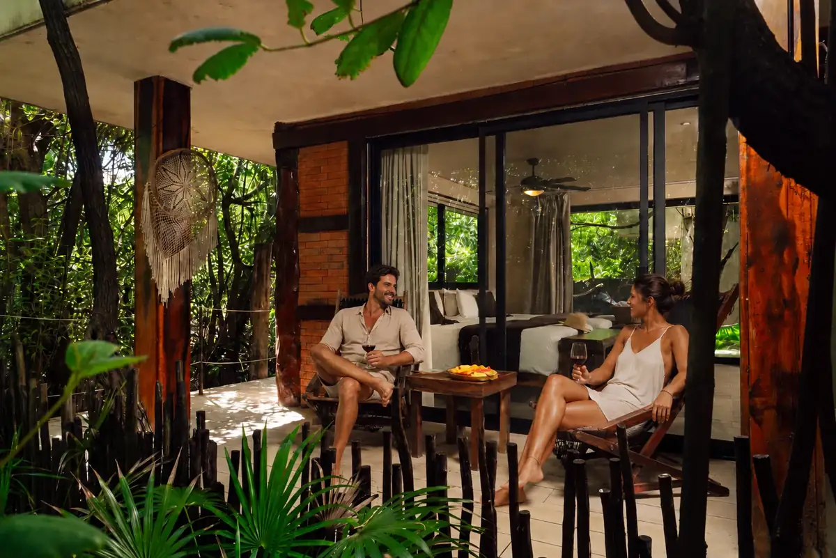 Couple relaxing with wine outside their room at Sunset Tulum